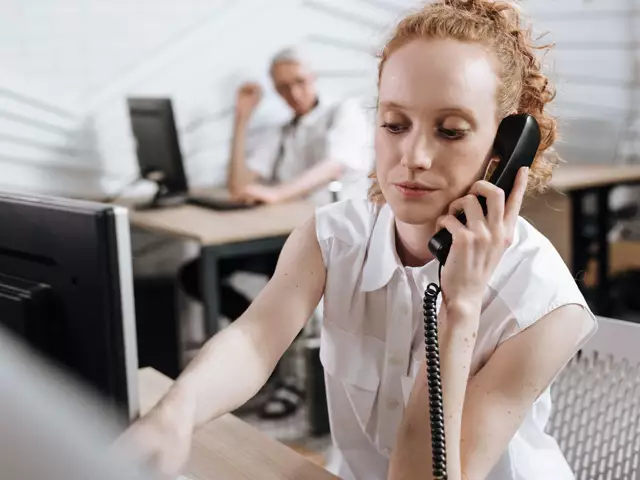 A woman talking on the phone at her desk