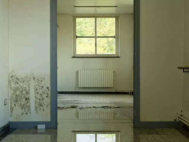 Standing water across the floor of an empty room